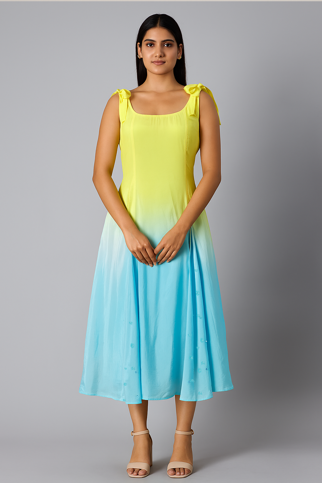Woman wearing a yellow to blue gradient dress against a gray background