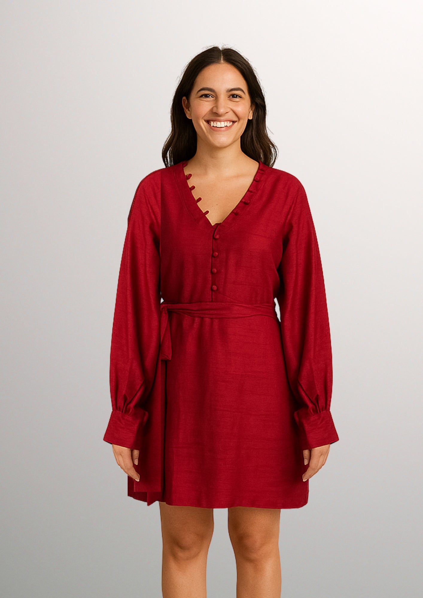 Woman wearing a red dress with potli in neck against a plain background
