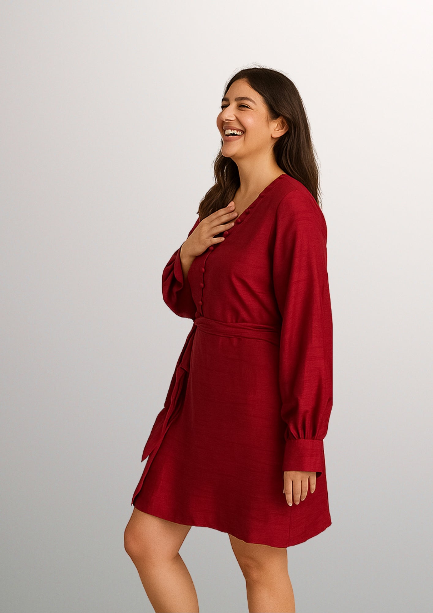 Woman wearing a red dress with potli in neck against a plain background
