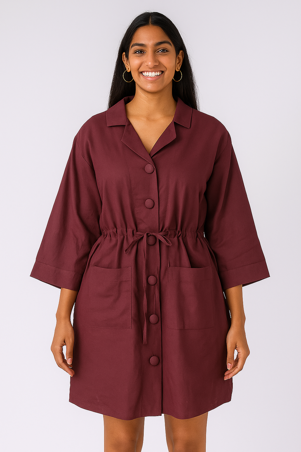 Woman wearing a burgundy dress with a belt on a white background