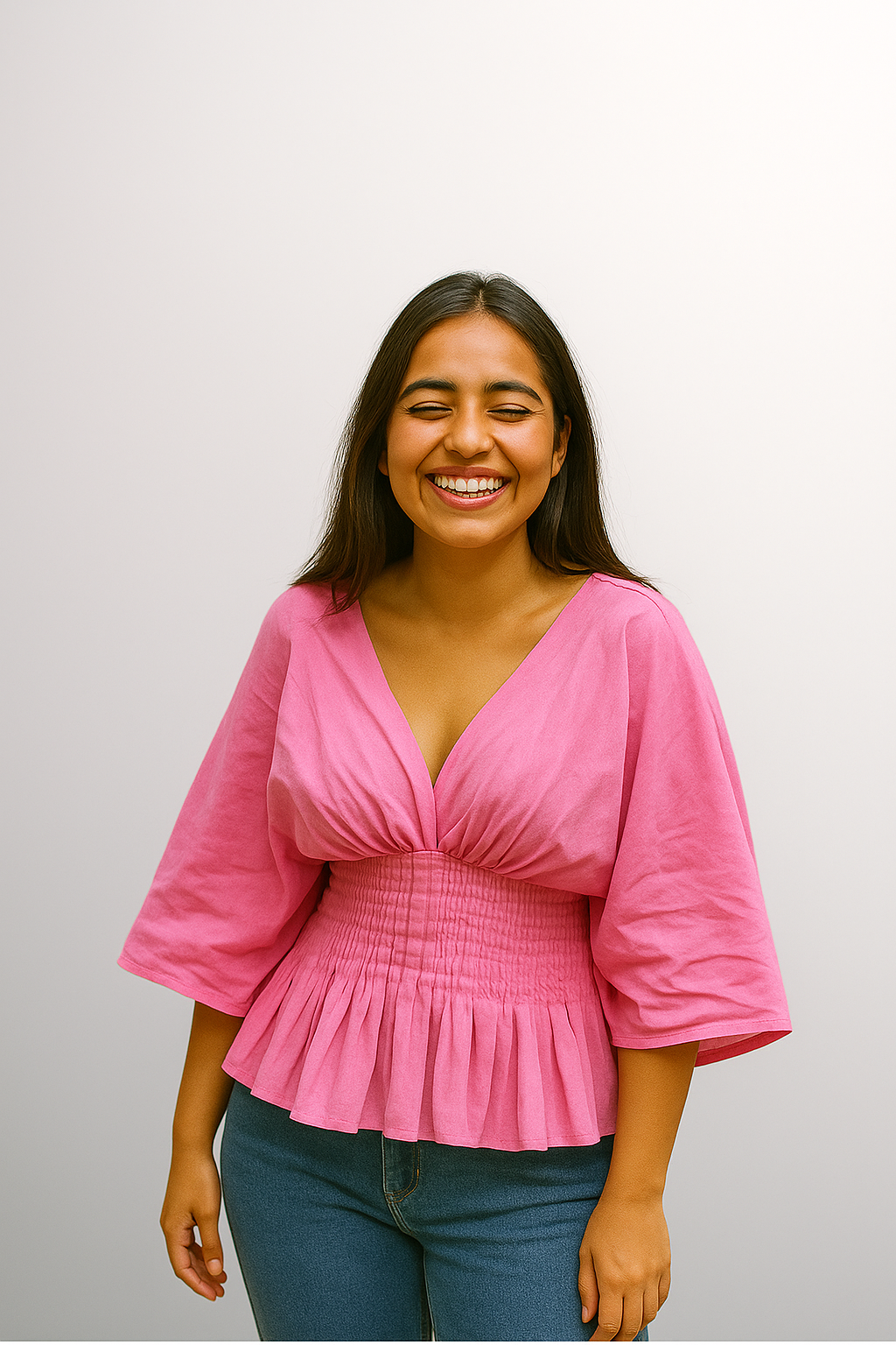 Woman wearing a pink blouse with a pin tec in the waist plain background
